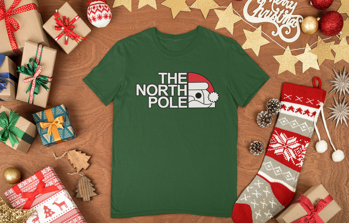 Green North Pole Santa Face T-shirt arranged with Christmas gifts, ornaments and a stocking