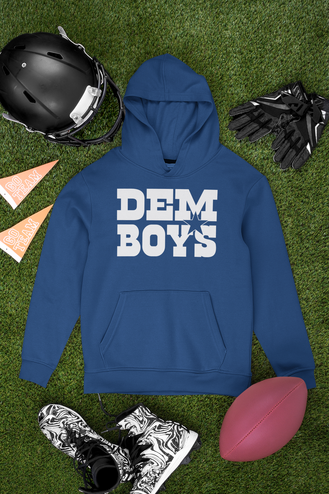 Blue Dem Boys hoodie arranged with a football, helmet and cleats on grass