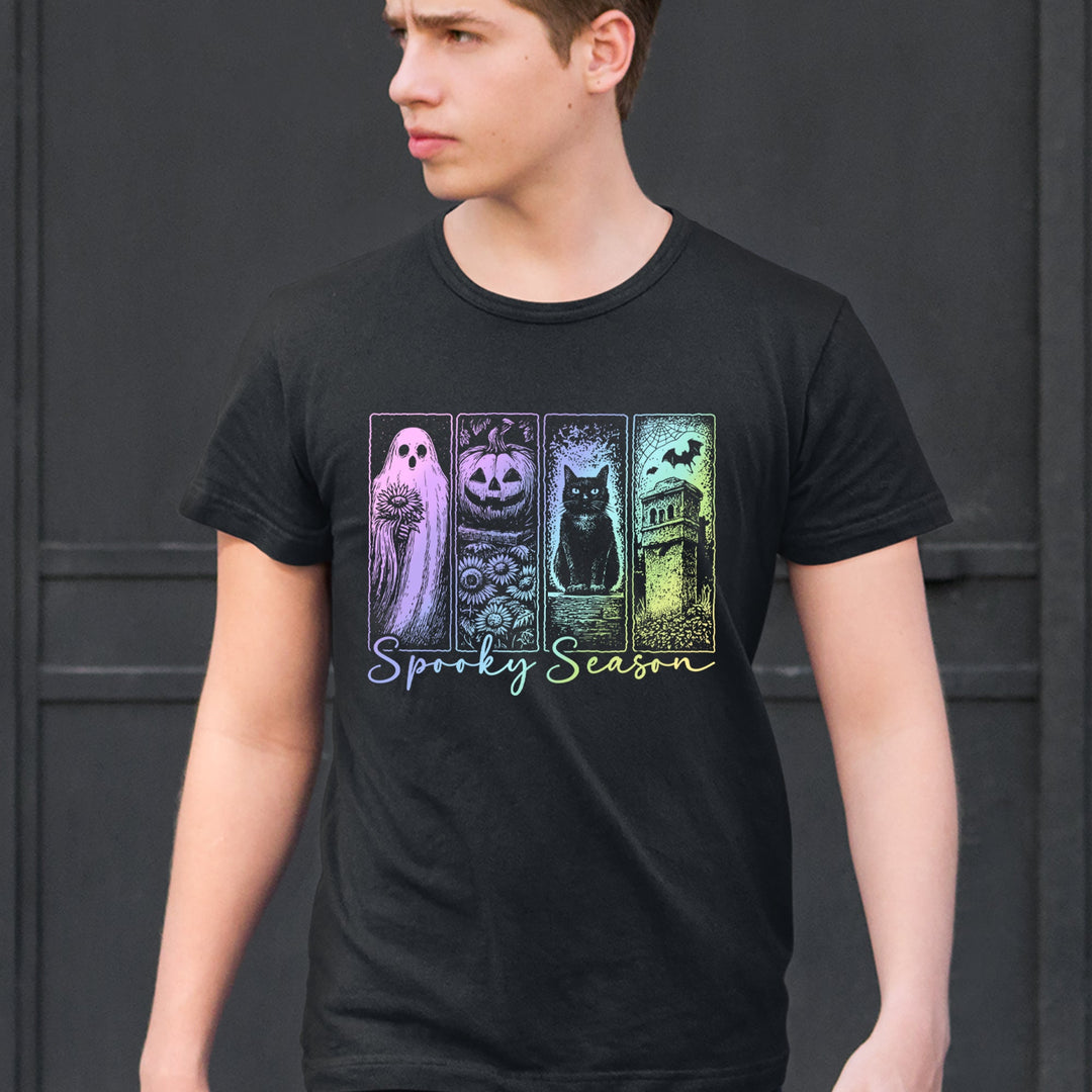 Person wearing a black Spooky Season T-shirt with pastel ghost, pumpkin, cat and bat artwork