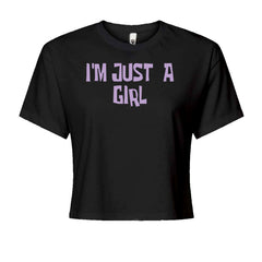 Women's boxy crop T-shirt with big lavender block text reading "I'M JUST A GIRL"