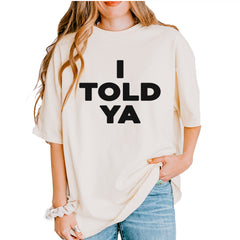 Black stacked "I TOLD YA" typography printed on an ivory garment-dyed heavyweight unisex t-shirt