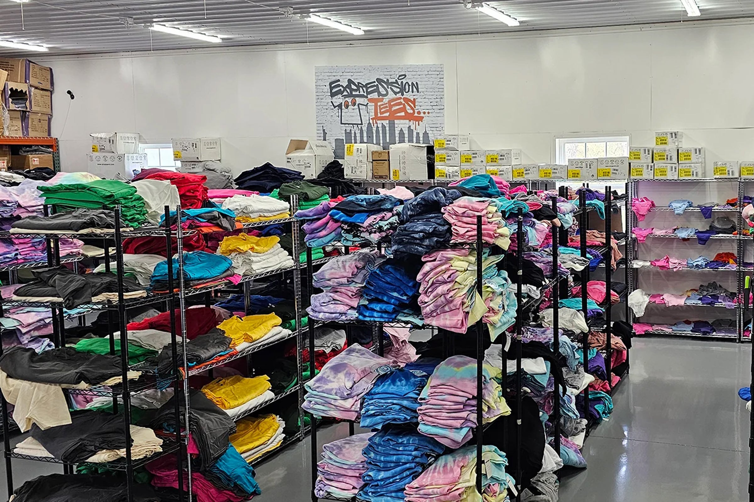 Expression Tees production shop with shelves of colorful custom apparel